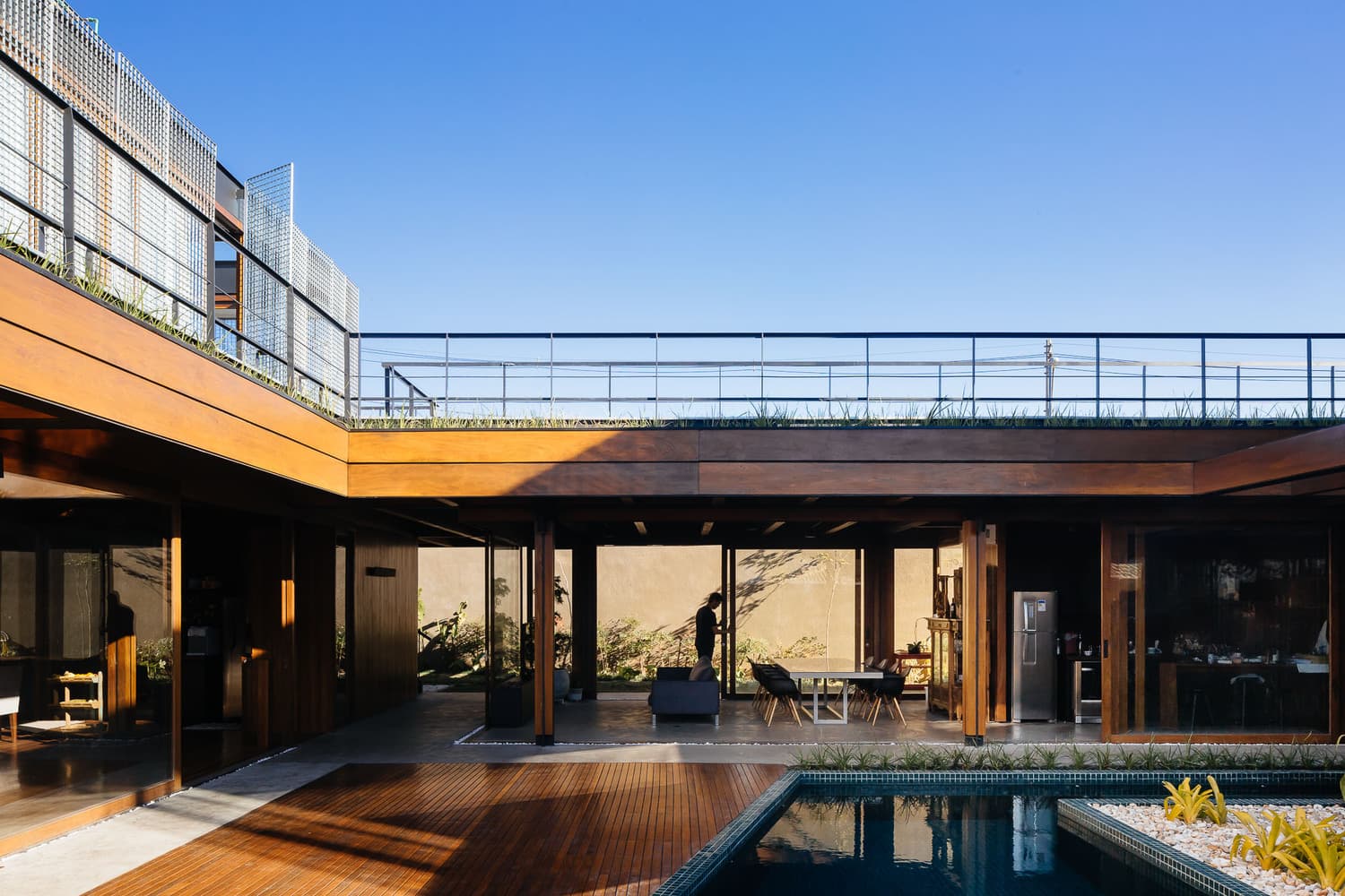 Pátio interno com piscina e estrutura de madeira