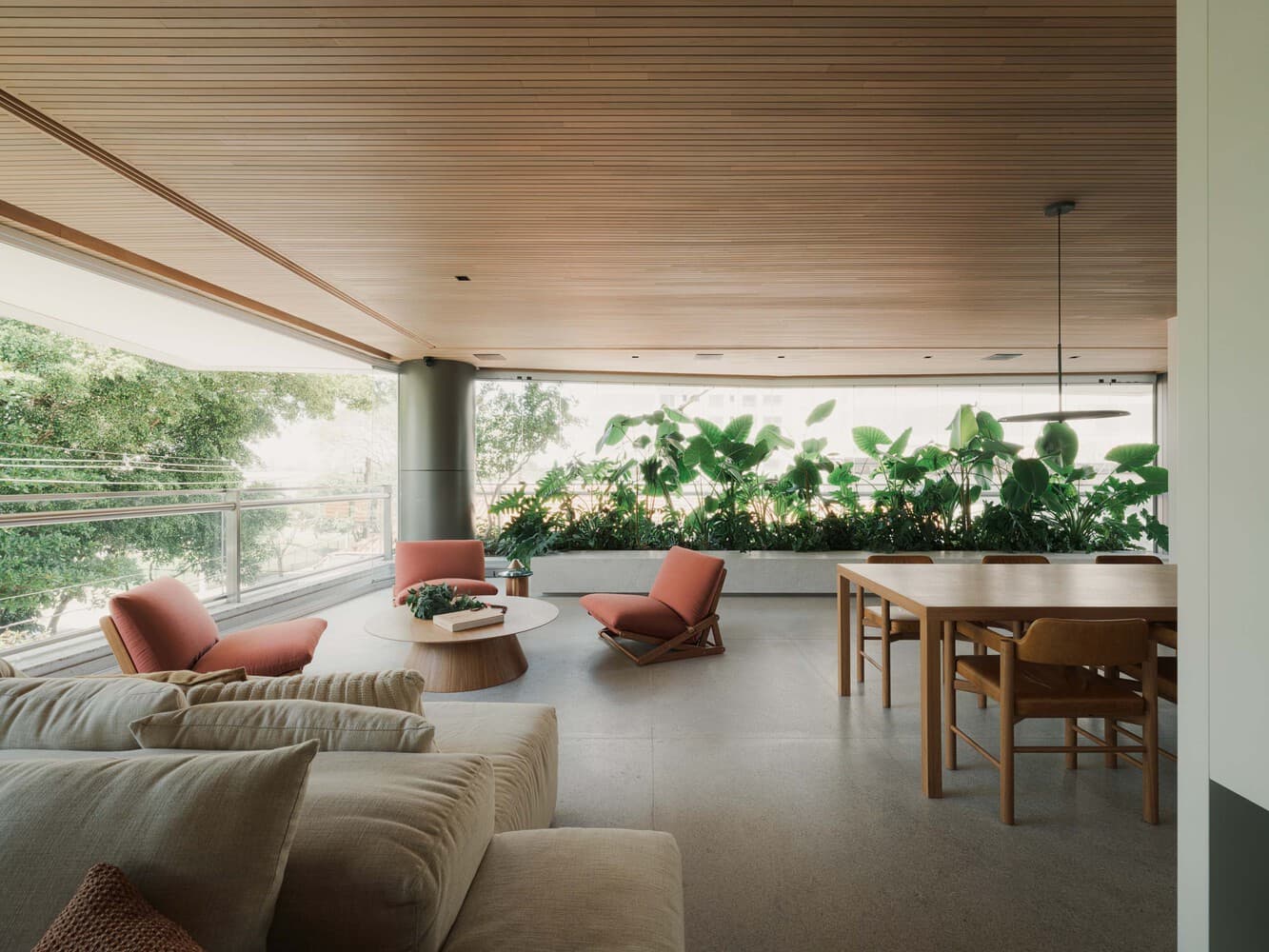 Living integrado à varanda com vegetação no Apartamento Linha